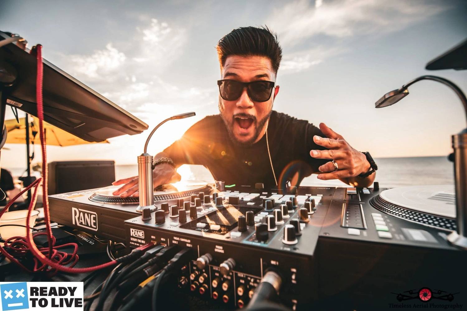 DJ Erge playing an outdoor set behind a pair of turntables